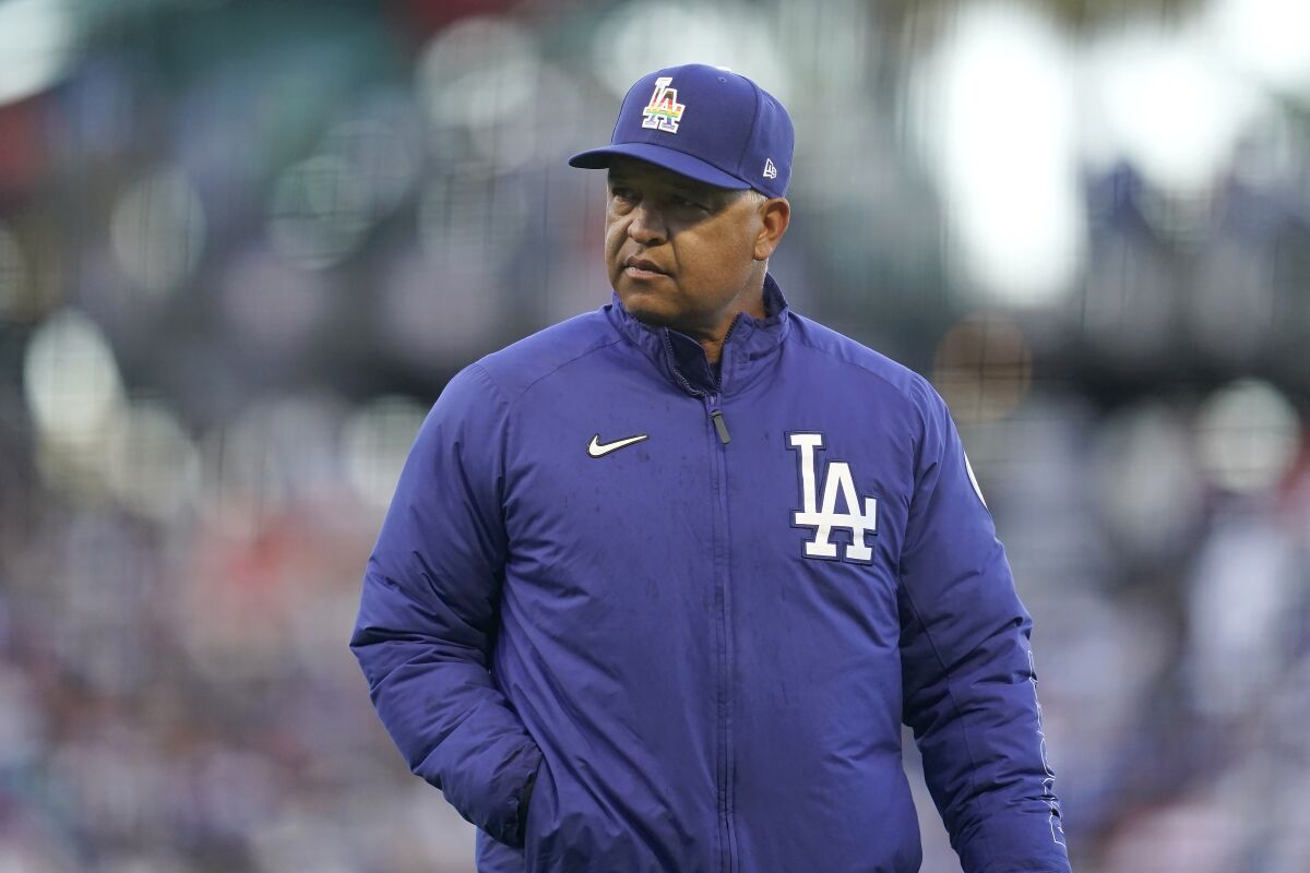 Dodgers manager Dave Roberts walks to the dugout after making a pitching change.
