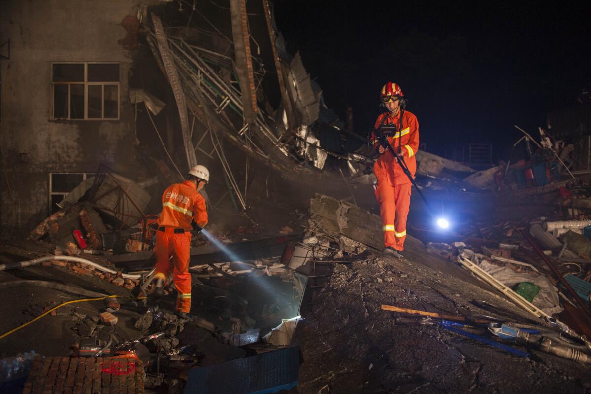 Los socorristas utilizan lámparas para buscar durante la noche a sobrevivientes entre los escombros de una fábrica que se derrumbó en la ciudad de Wenling, provincia de Zhejiang, en el este de China.