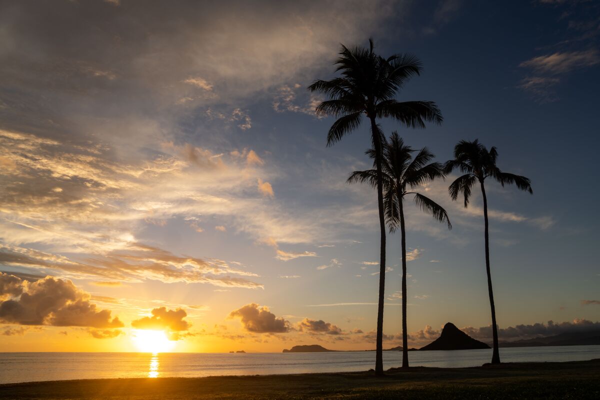 The sun rises over Kualoa Regional Park on the northeastern shore of the island of Oahu.