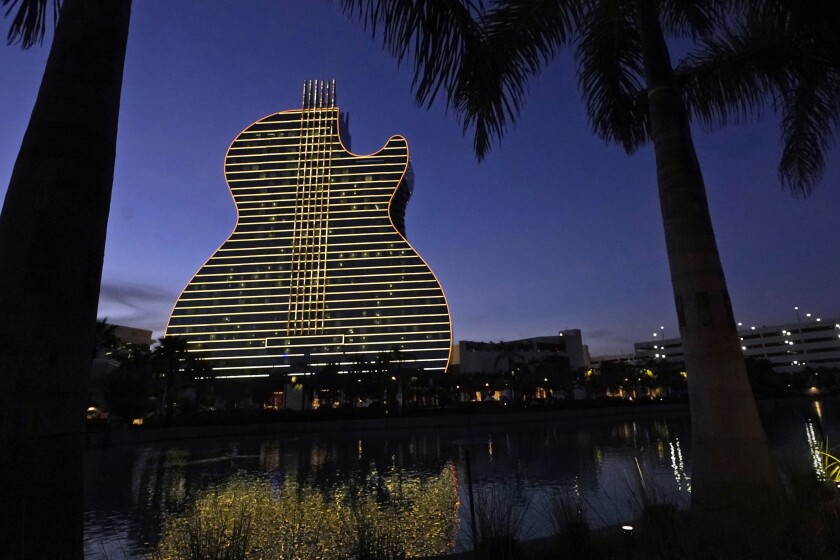 FILE- In this Jan. 19, 2021, file pot, The Guitar Hotel at Seminole Hard Rock Hotel & Casino Hollywood is illuminated at night in Hollywood, Fla. Florida Gov. Ron DeSantis reached an agreement with the state's Seminole Tribe on Friday, April 23, 2021, that would greatly expand gambling in the state, including the introduction of legalized sports wagering. (AP Photo/Wilfredo Lee)