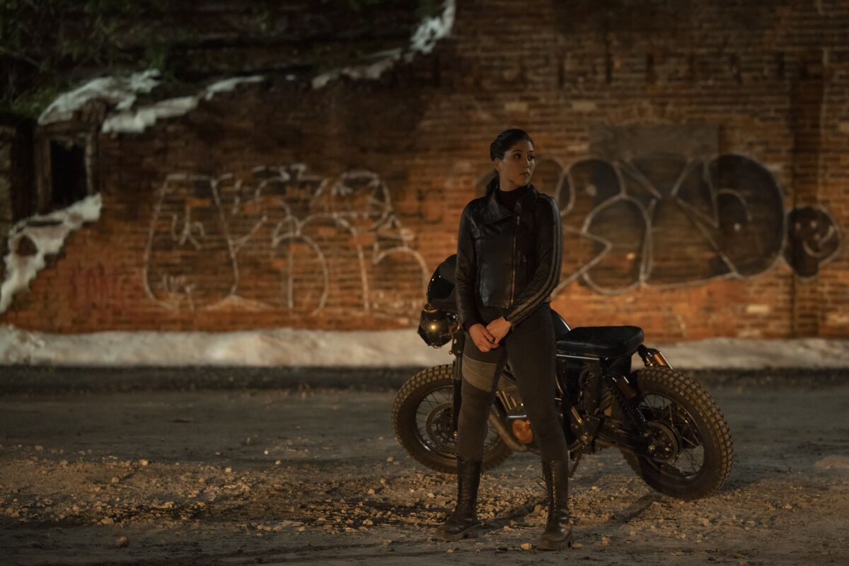 A woman standing by a motorcycle