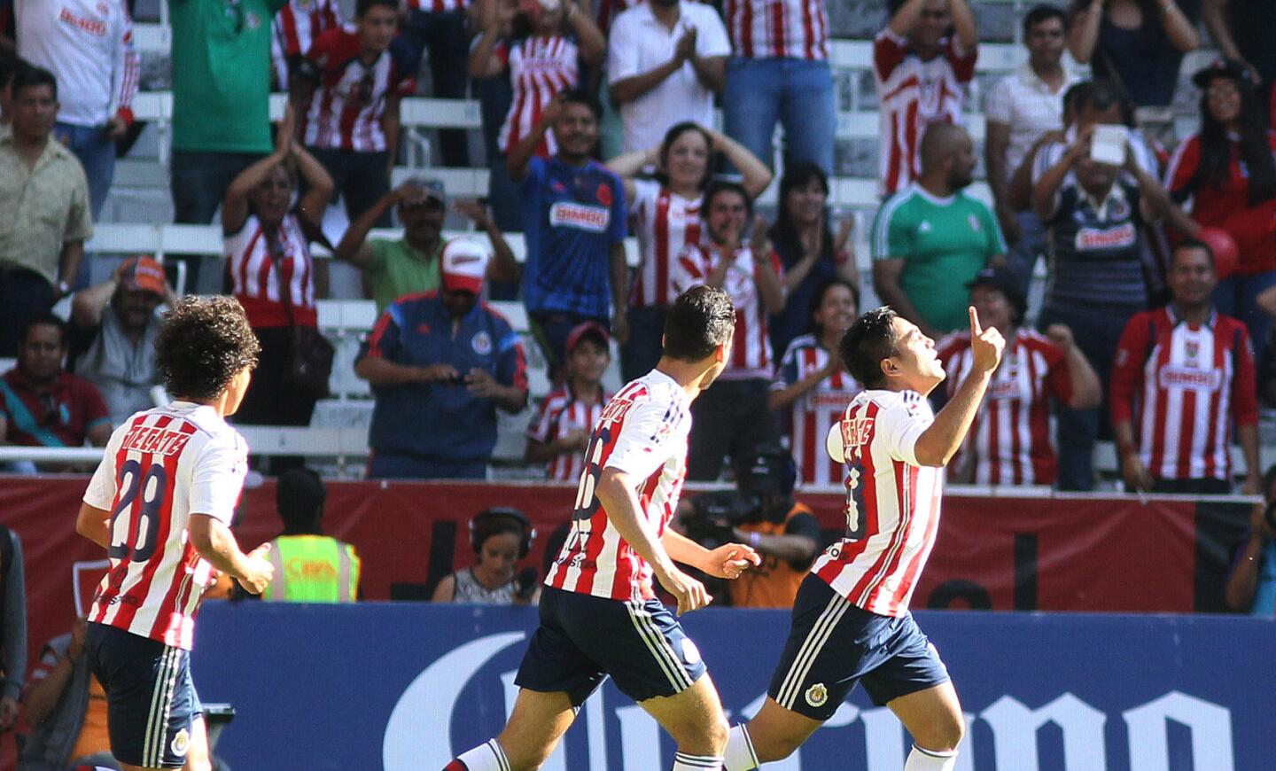 Marco Fabián (der) festeja su primer gol sobre el Atlas; las Chivas ganaron 4-1.