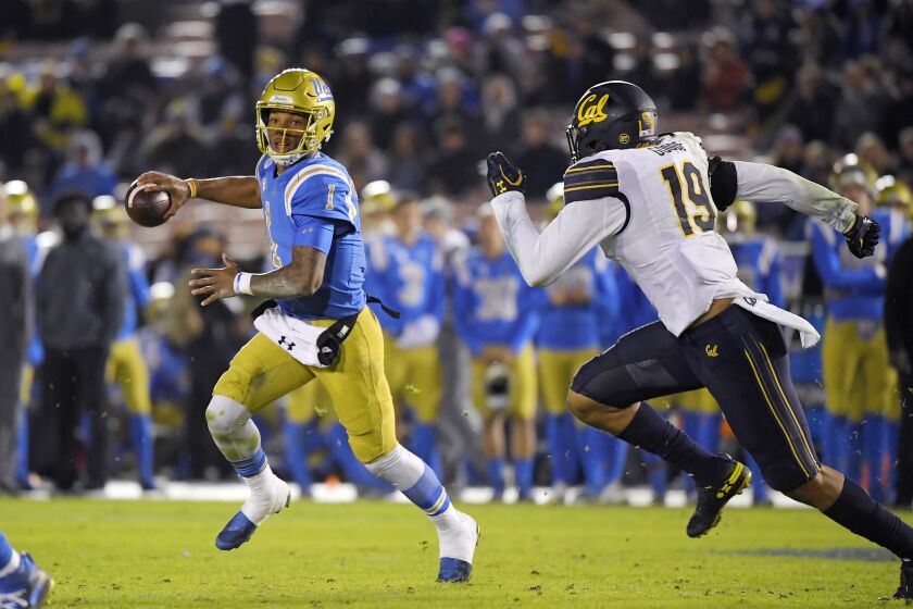 UCLA quarterback Dorian Thompson-Robinson, left, tries to pass while under pressure from California linebacker Cameron Goode during the second half of an NCAA college football game Saturday, Nov. 30, 2019, in Pasadena, Calif. California won 28-18. (AP Photo/Mark J. Terrill)