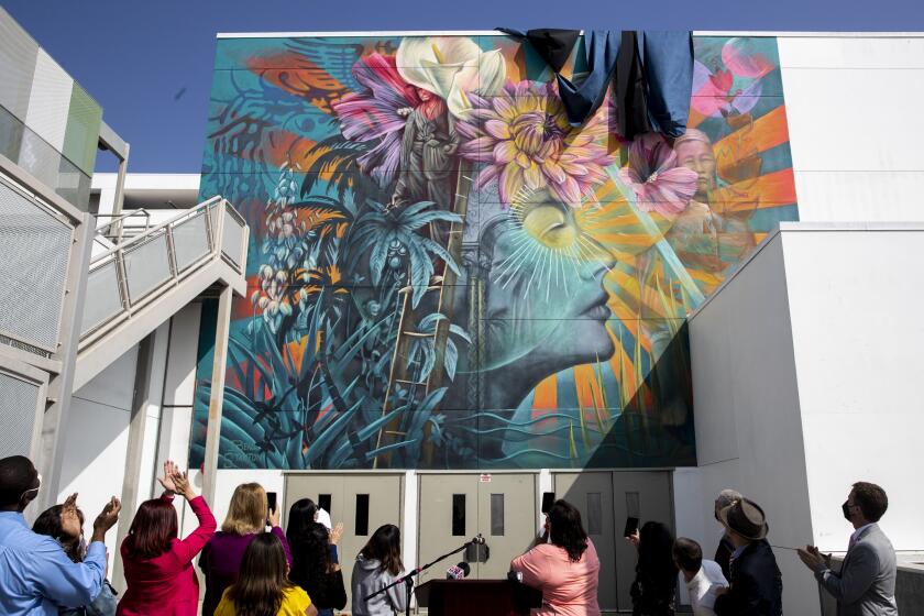 LOS ANGELES, CA - September 15,2021: LAUSD officials and community members cheer as an updated version of the Ava Gardner Mural at the Robert F. Kennedy Community Schools is unveiled on Wednesday, Sept. 15, 2021 in Los Angeles, CA. The update of the mural, created by artist Beau Stanton, had been delayed by over two years due to the COVID-19 pandemic. (Brian van der Brug / Los Angeles Times)