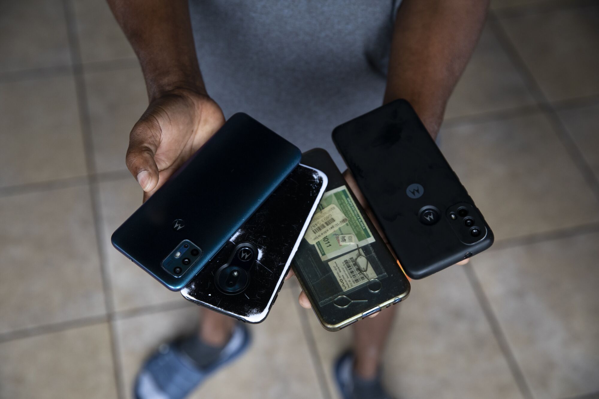 A man shows the phones he and his wife use to try to get an appointment