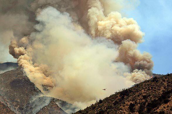 Smoke billows from the Morris fire north of Azusa. Climatologist Bill Patzert estimated that smoke over the Los Angeles Basin would hang around until Sunday because a high-pressure system was not moving.