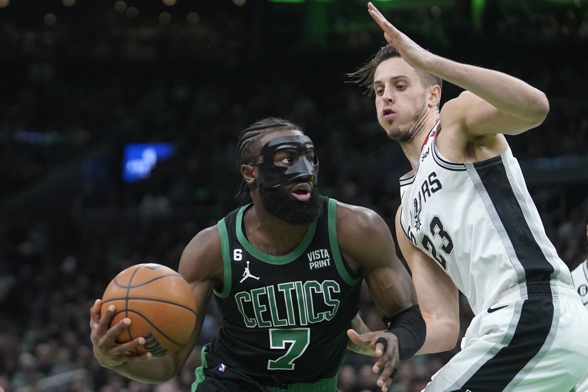 Boston Celtics guard Jaylen Brown (7) drives toward the basket as San Antonio Spurs forward Zach Collins (23) defends in the first half of an NBA basketball game, Sunday, March 26, 2023, in Boston. (AP Photo/Steven Senne)