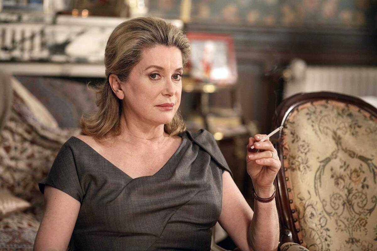 Catherine Deneuve grimaces while holding a cigarette in “A Christmas Tale” (2008).