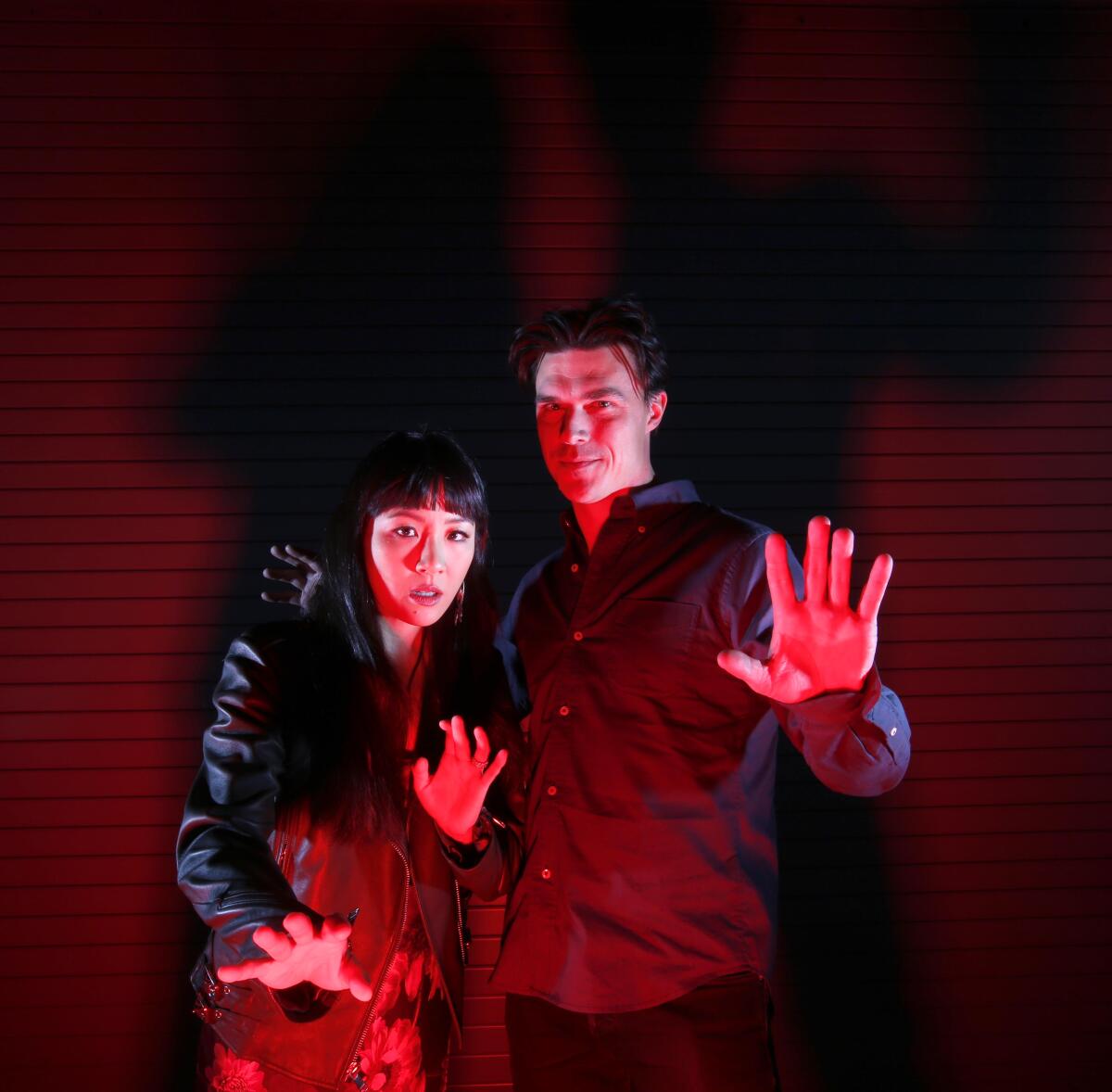 Constance Wu and Finn Wittrock in a spooky red light. 