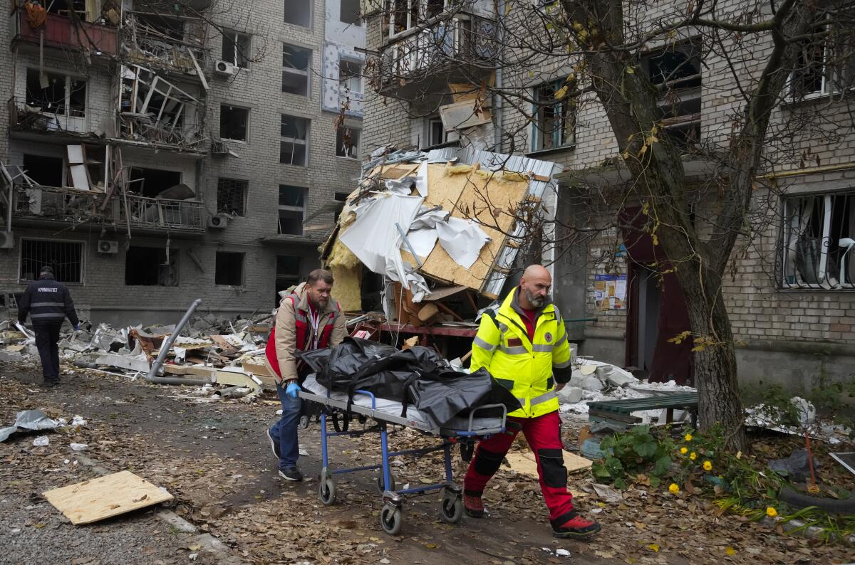 Paramédicos llevan el cadáver de una persona hallado bajo los escombros 