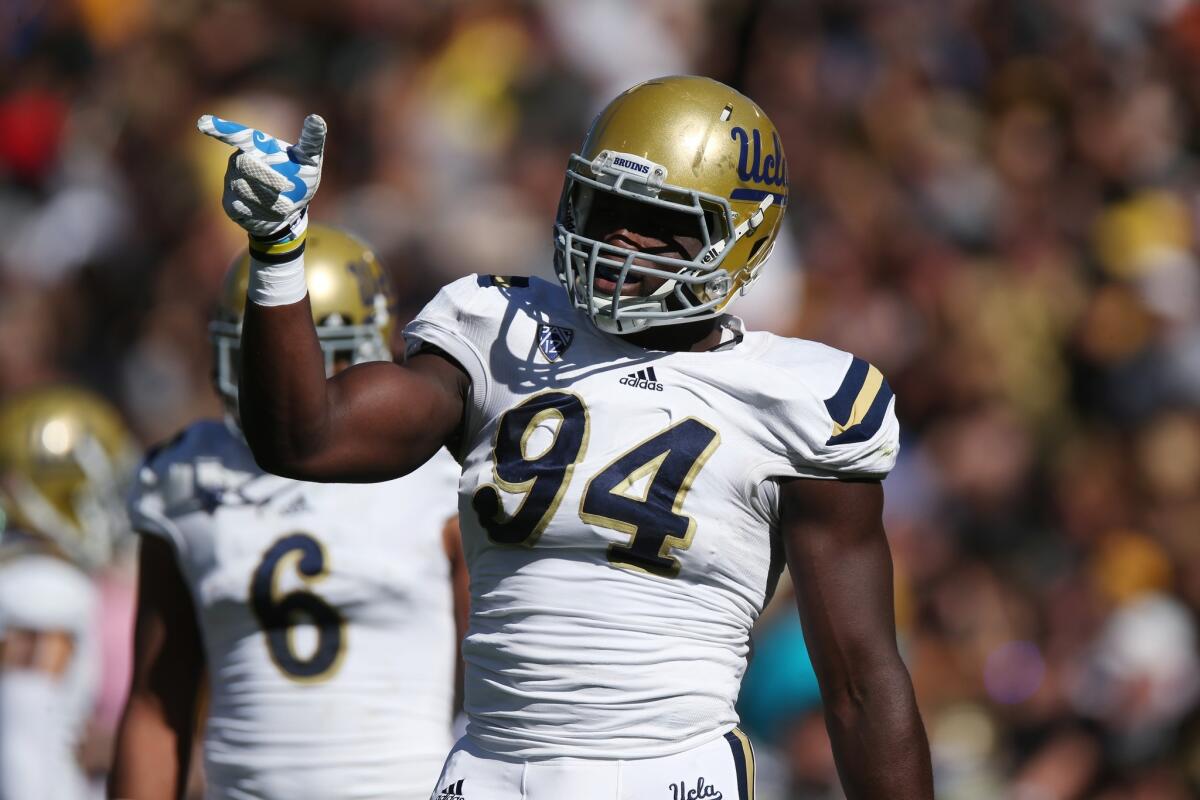 UCLA defensive lineman Oqamagbe Odighizuwa gestures to his teammates during the first quarter of the Bruins' 40-37 double overtime win over Colorado.
