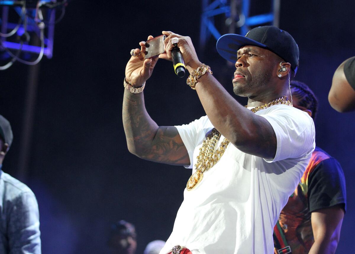 Rapper 50 Cent takes a picture of the crowd while performing Sunday at MetLife Stadium in New Jersey.