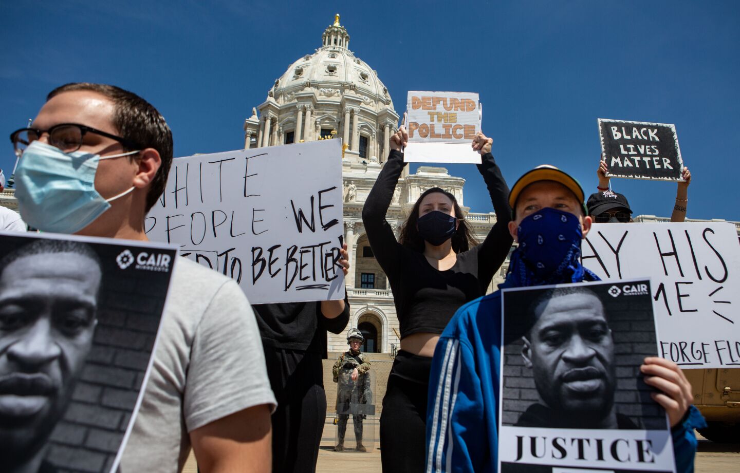 Demonstrators stand on the steps of the Minnesota State Capitol on Sunday in Minneapolis.