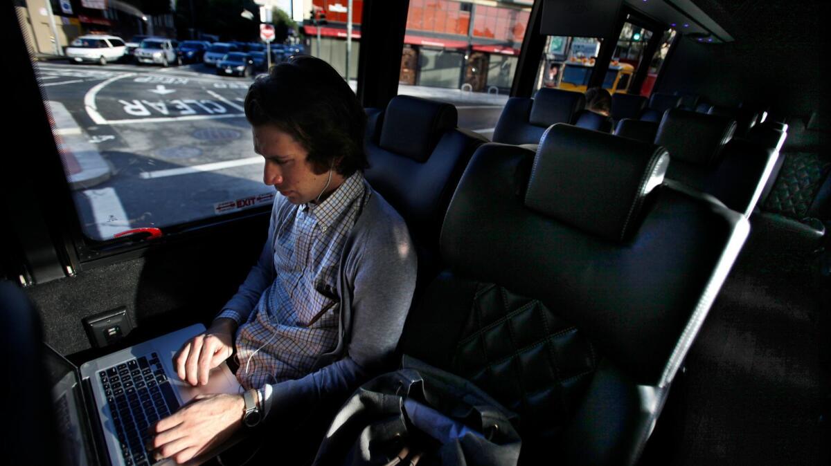 An employee of NetBase sits on one of the private buses that tech companies in Silicon Valley use to ferry their workers from downtown San Francisco to campuses in cities such as Mountain View.