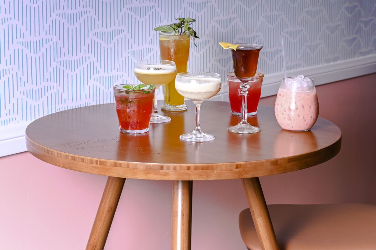 A variety of mixed drinks are arranged on a table.