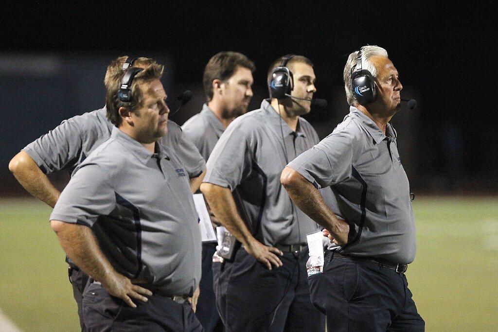 Newport Harbor coaches, led by head man Jeff Brinkley, watch as the referees try to figure out two flags in the first half against Trabuco Hills on Friday.