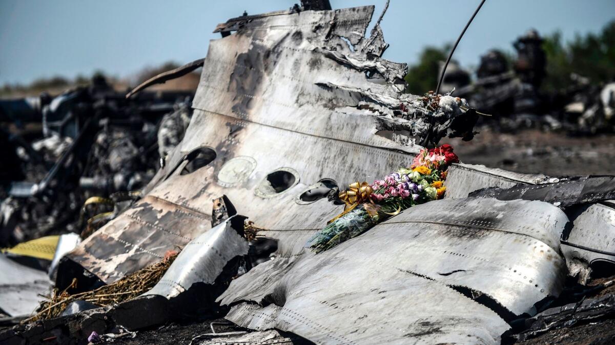 Flowers, left by parents of an Australian victim of the crash, lie on a piece of the downed Malaysia Airlines jet near the village of Hrabove in the Donetsk region, on July 26, 2014.