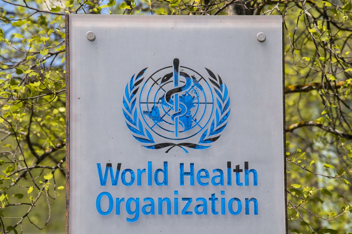 FILE - The logo and building of the World Health Organization (WHO) headquarters in Geneva, Switzerland, 15 April 2020. An expert group convened by the World Health Organization says there may be some benefit to giving a second booster dose of coronavirus vaccine to the most vulnerable people amid the continuing global spread of omicron and its subvariants. In a statement issued on Tuesday, May 17 2022 the U.N. health agency said there was increasing evidence that a second booster dose of COVID-19 vaccine would benefit health workers, people over age 60 and those with weak immune systems. (Martial Trezzini/Keystone via AP, file)