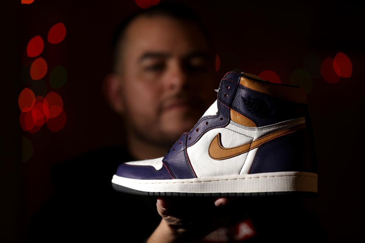 Manuel Cruz holds up a Nike shoe