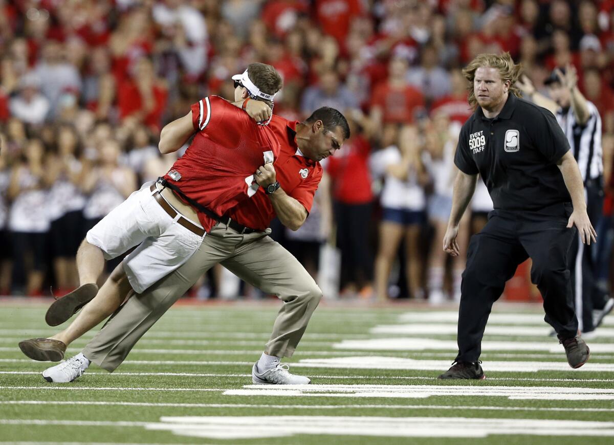 Ohio State strength and conditioning coach Anthony Schlegel tackles a fan who ran onto the field Sept. 27 during the Buckeyes' game against Cincinnati.