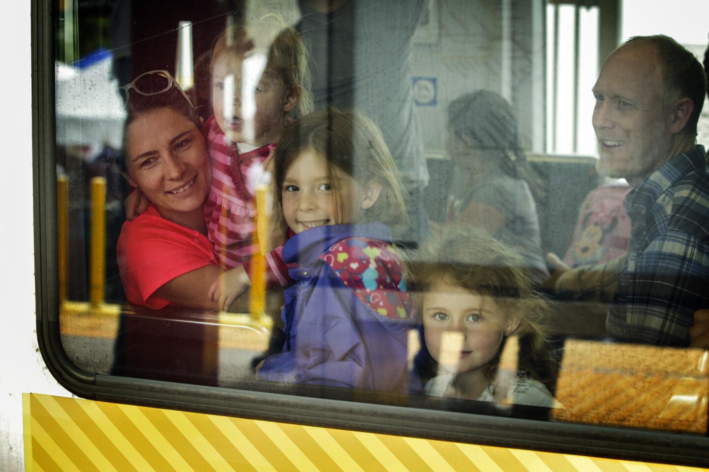 A family enjoys a ride on the Metro Gold Line train on the opening day of service on the $1-billion, 11.5-mile extension through the Foothills. The line will transform the lives and commutes of San Gabriel Valley residents, officials say.