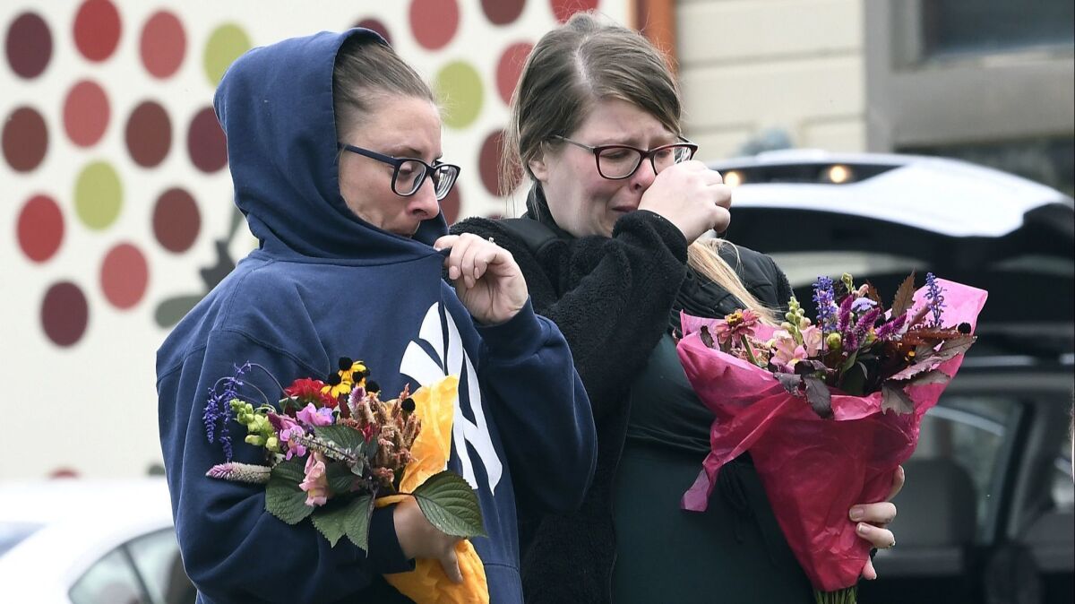 People place flowers at the scene where 20 people died as the result of a limousine crashing into an unoccupied SUV in Schoharie, N.Y.