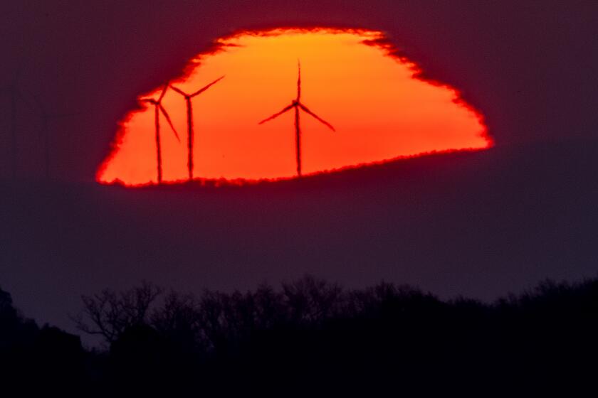 FILE - Wind turbines stand in front of the rising sun in Frankfurt, Germany, Friday, March 11, 2022. A United Nation-backed panel plans to release a highly anticipated scientific report on Monday, April 4, 2022, on international efforts to curb climate change before global temperatures reach dangerous levels. (AP Photo/Michael Probst, File)