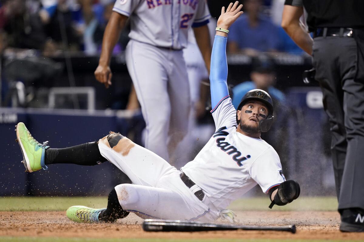 Miami Marlins' Miguel Rojas scores on a single hit by Jorge Alfaro during the eighth inning of a baseball game against the New York Mets, Thursday, Aug. 5, 2021, in Miami. The Marlins won 4-2. (AP Photo/Lynne Sladky)