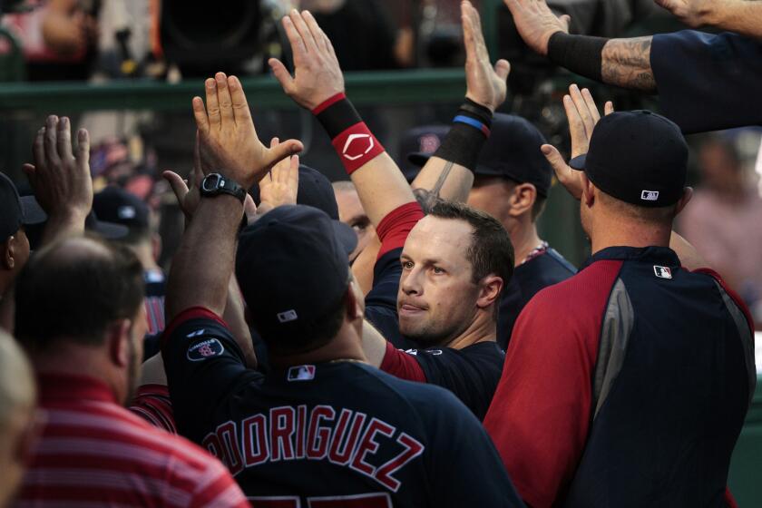 Red Sox outfielder Daniel Nava gets high-fives in the dugout after scoring in the second inning against the Angels on July 5, 2013.