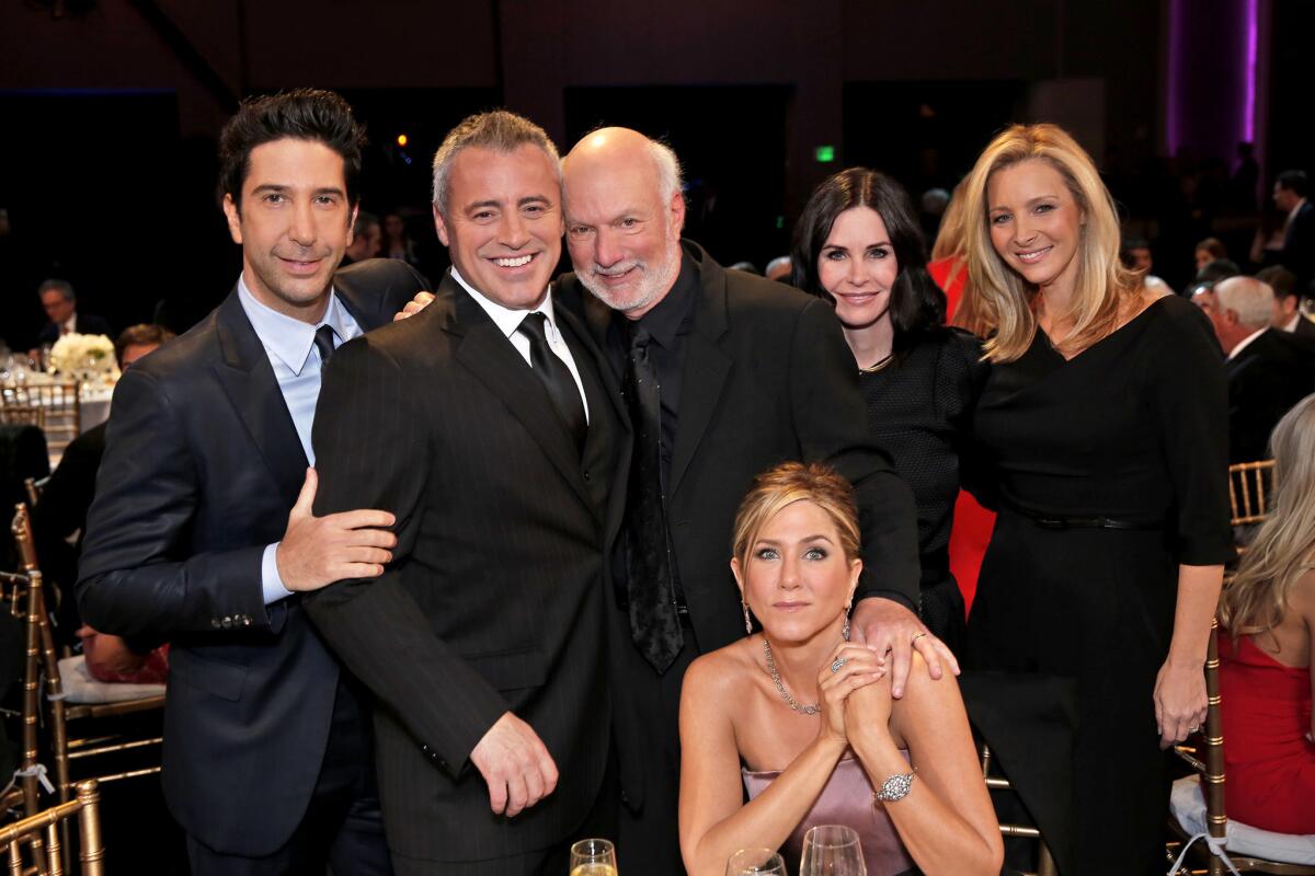 Director James Burrows, center, poses with the reunited cast of "Friends," from left, David Schwimmer, Matt LeBlanc, Jennifer Aniston, seated, Courteney Cox and Lisa Kudrow on Jan. 24.