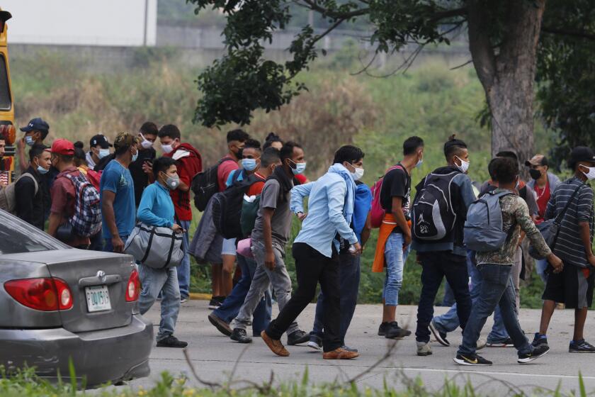 Migrantes que buscan llegar a la frontera de México con Estados Unidos caminan por la carretera cerca de Choloma, Honduras, el jueves 14 de enero de 2021. (AP Foto/Delmer Martínez)