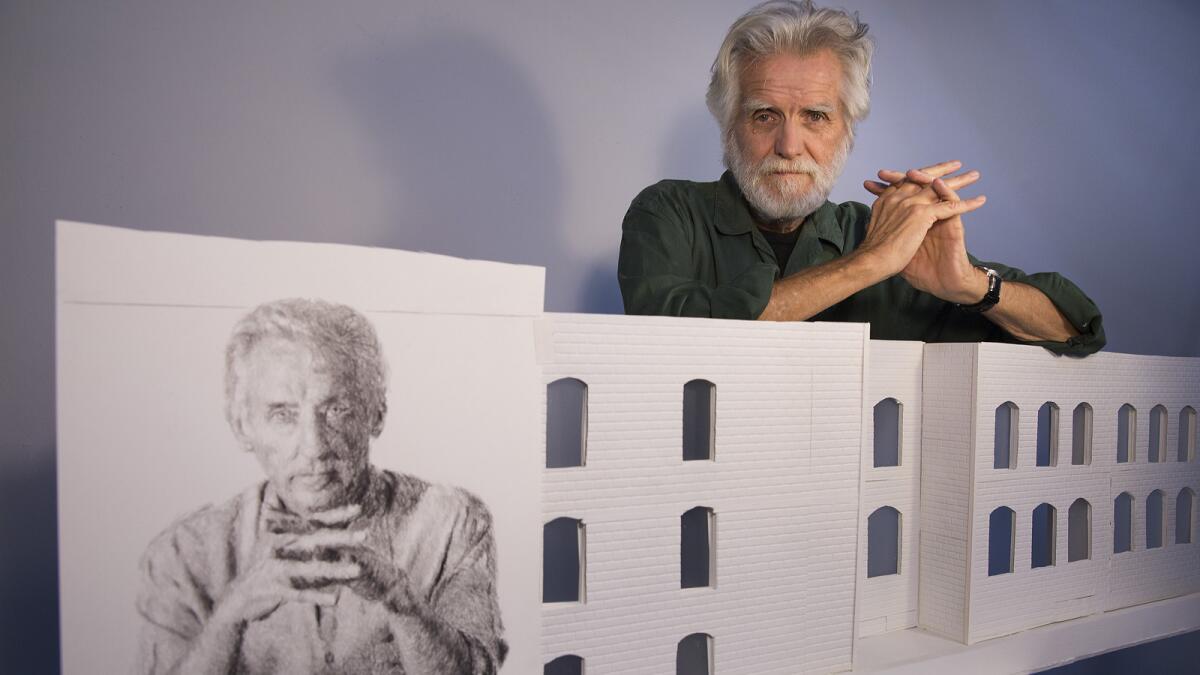 Artist Kent Twitchell in his studio with a sketch of Ed Ruscha. Twitchell is preparing to re-paint his famed mural of Ed Ruscha on the exterior of the American Hotel in the Arts District of Los Angeles.