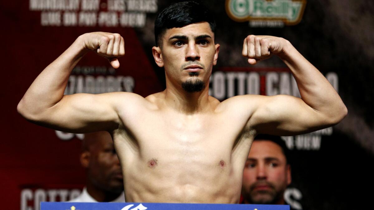 Randy Caballero poses on the scale during his weigh-in Friday in Las Vegas.