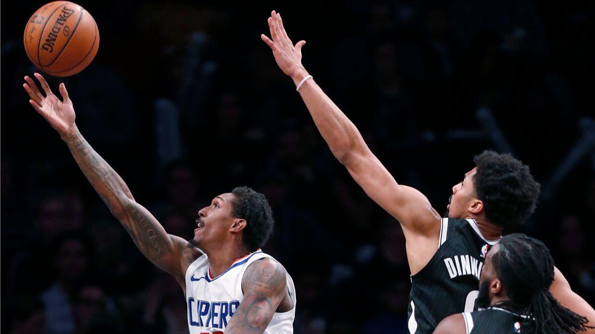 Clippers guard Lou Williams (23) goes up for a layup as Brooklyn Nets guard Spencer Dinwiddie and forward DeMarre Carroll defend during the second half Monday.