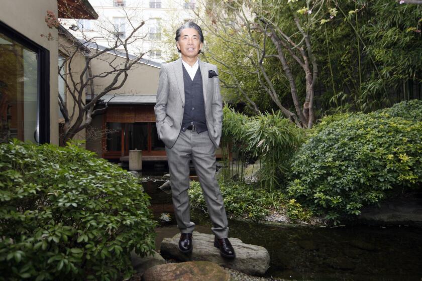 FILE - In a March 24, 2009 file photo, Japanese fashion designer Kenzo Takada poses outside his Paris house.