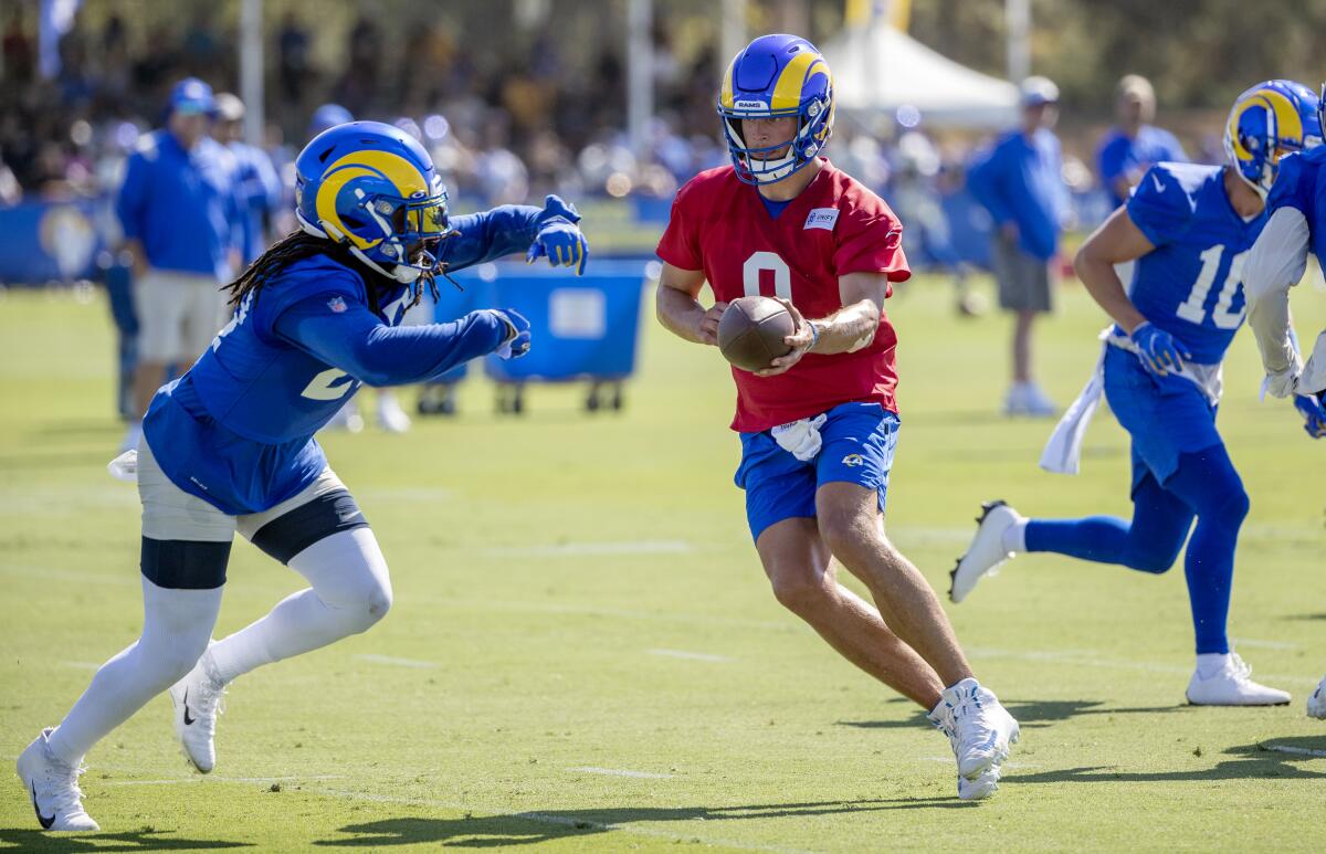 Rams quarterback Matthew Stafford looks to hand-off to running back Darrell Henderson Jr. at training camp.