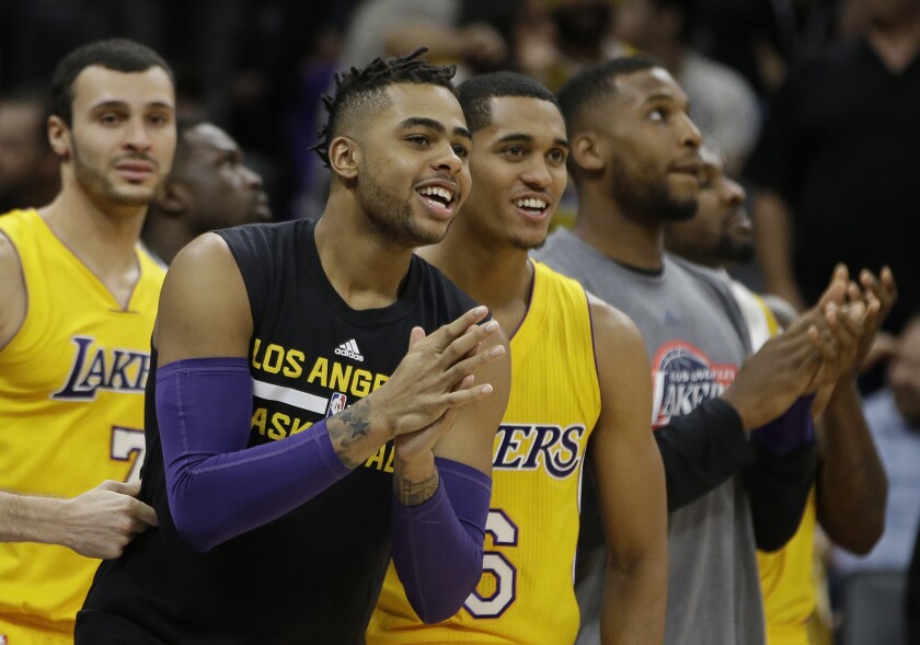 Lakers guard D'Angelo Russell, second from left, Jordan Clarkson (6) and Larry Nance Jr. (7) join their teammates in celebrating in the closing moments of a 101-91 win over the Sacramento Kings on Nov. 10.