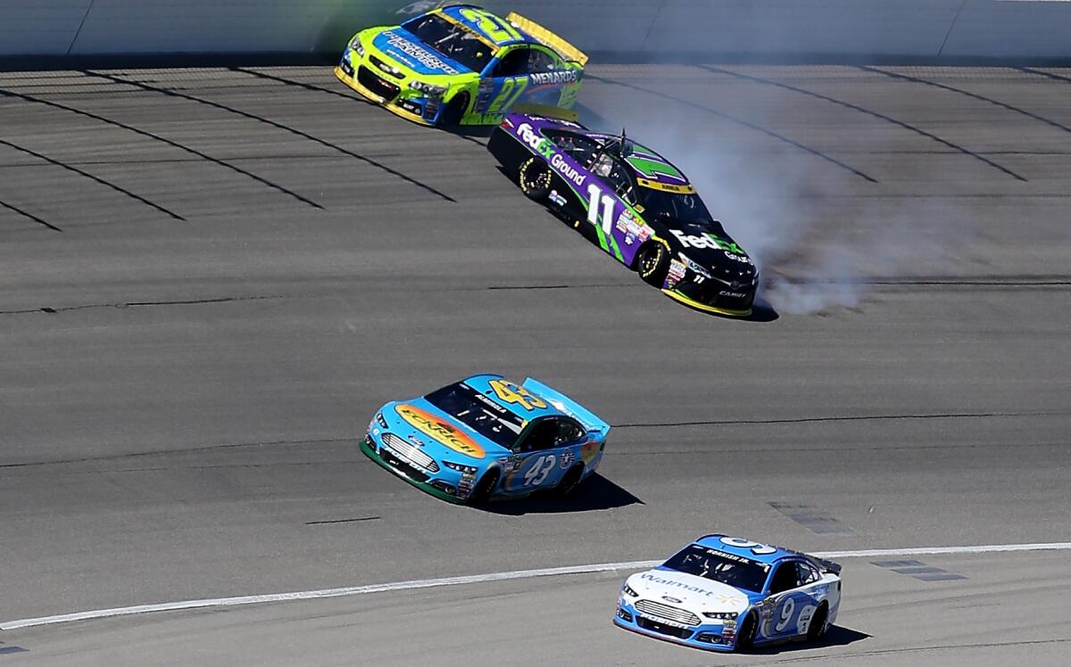 NASCAR driver Denny Hamlin spins out in his No. 11 Toyota after hitting the wall early Sunday in the Sprint Cup Series race at Chicagoland Speedway.