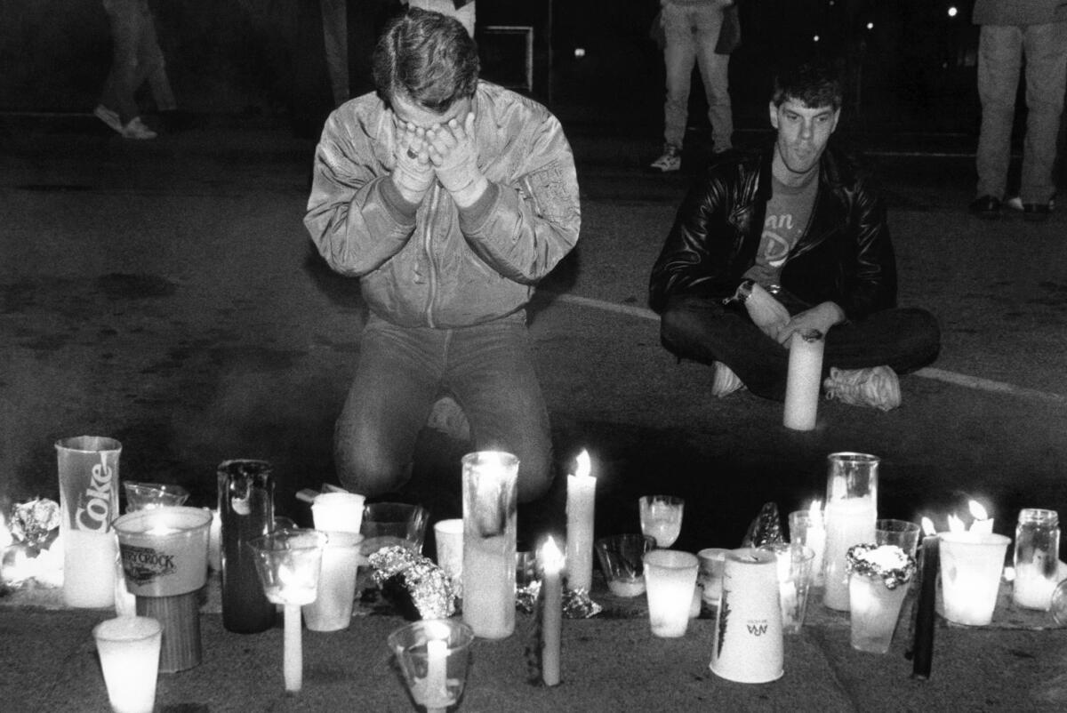 A man weeps in front of a makeshift memorial to AIDS victims during the 1990 AIDS Candlelight Memorial in San Francisco. (Bill Beattie / Associated Press)