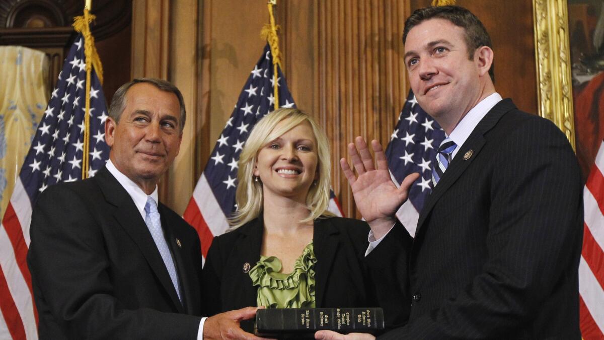 John Boehner left, administers the House oath to Rep. Duncan Hunter, R-Calif., as his wife, Margaret, looks on Jan. 5, 2011.