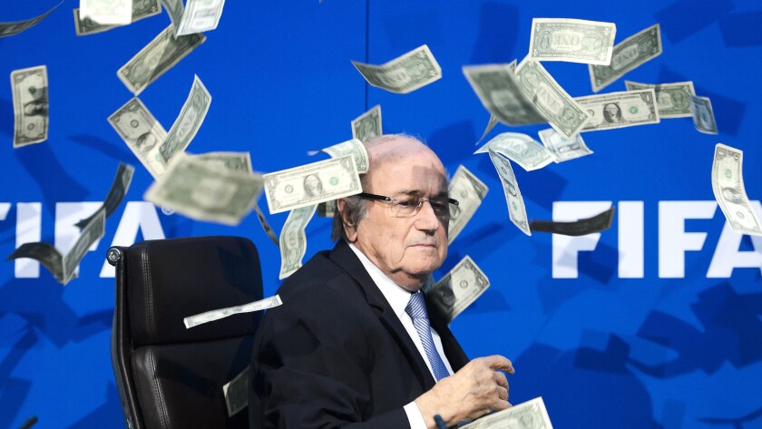 FIFA President Sepp Blatter reacts after a British comedian interrupted a news conference in Zurich on July 20 by throwing fake dollar bills.