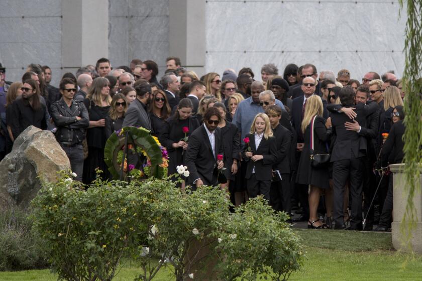 Family members lay flowers graveside Friday at the funeral for Soundgarden frontman Chris Cornell at the Hollywood Forever Cemetery.