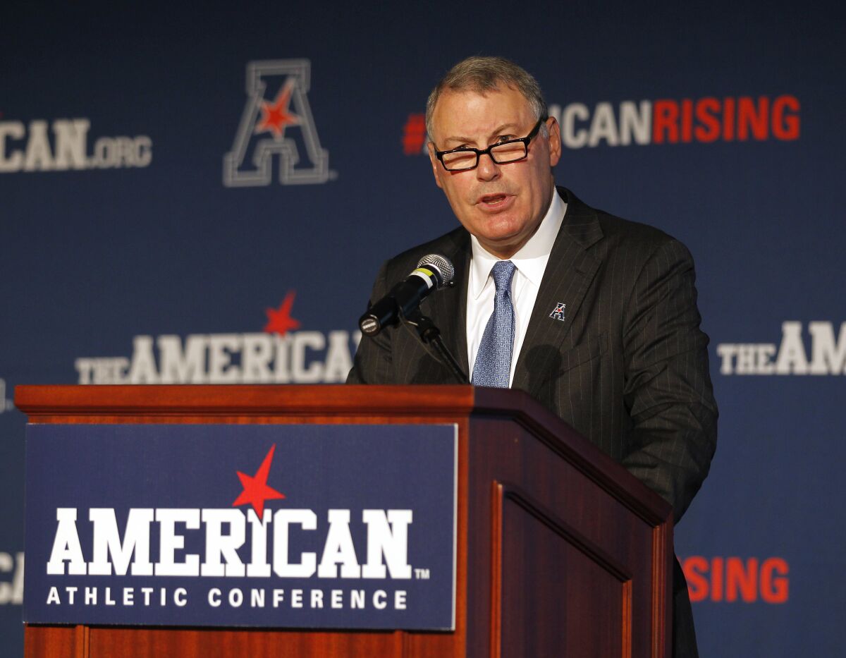 FILE - In this Aug. 4, 2015, file photo, American Athletic Conference Commissioner Mike Aresco addresses the media during an NCAA college football media day in Newport, R.I. Aresco vehemently denied that his league has ever “plotted” with ESPN to undermine another conference by poaching its schools. Aresco addressed conference realignment Wednesday, Aug. 4, 2021, during the AAC’s virtual football media day, saying the league is not actively looking to add schools. (AP Photo/Stew Milne, File)