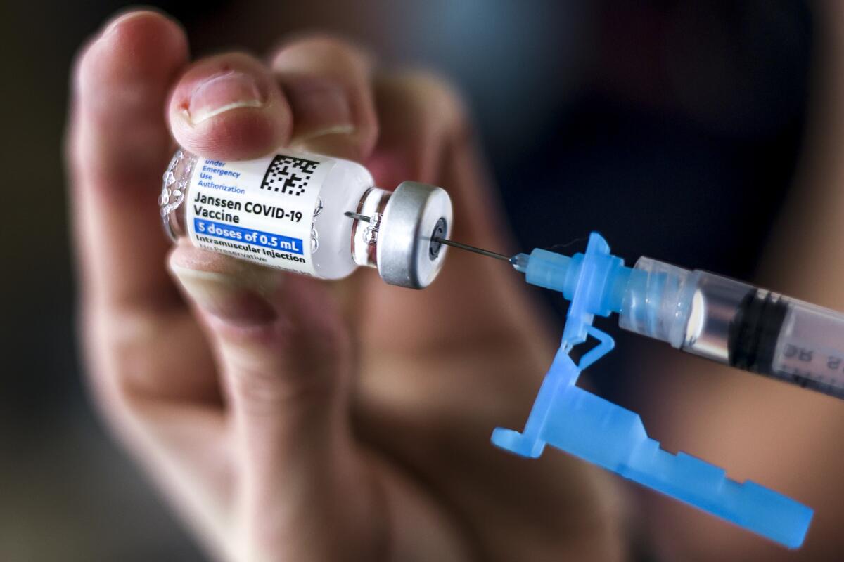 A dose of Johnson & Johnson's COVID-19 vaccine is extracted into a syringe. 