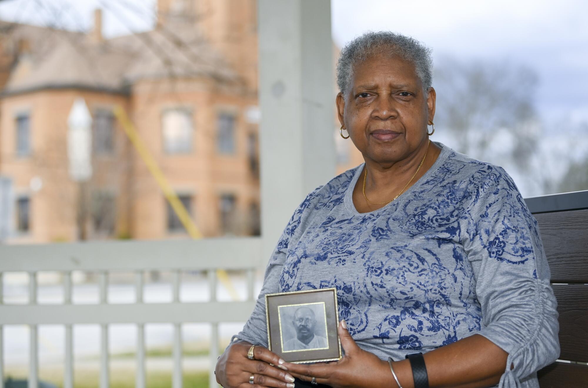 Janie Holmes holds a photo of her great-grandfather Alex Ware 