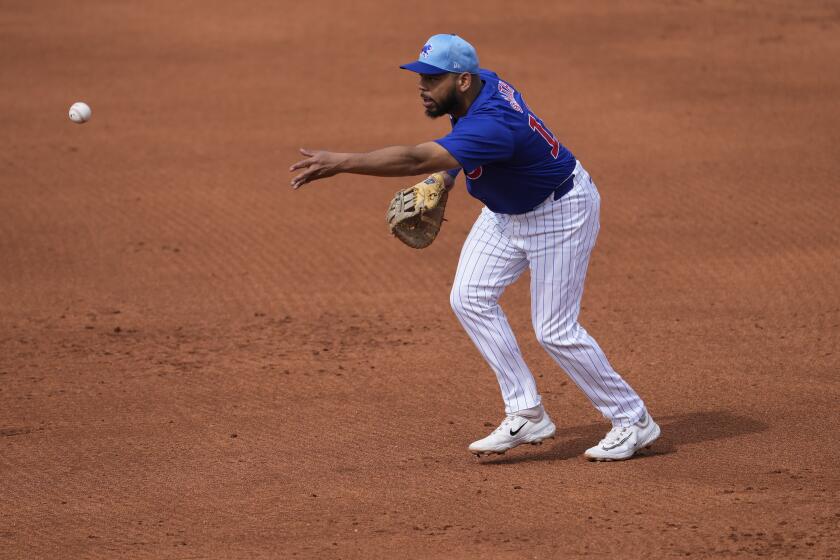 Chicago Cubs' Dominic Smith throws out Los Angeles Angels' Ehire Adrian during the fifth inning of a spring training baseball game, Wednesday, March 6, 2024, in Mesa, Ariz. (AP Photo/Matt York)
