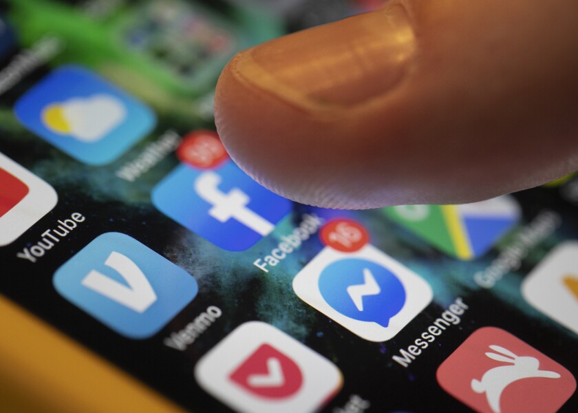 Finger hovering over social media apps on a phone