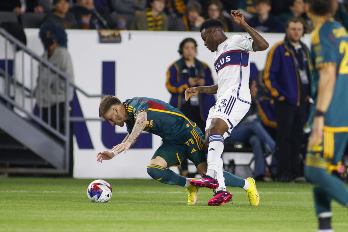 Galaxy forward Tyler Boyd and Vancouver Whitecaps defender Javain Brown vie for the ball.