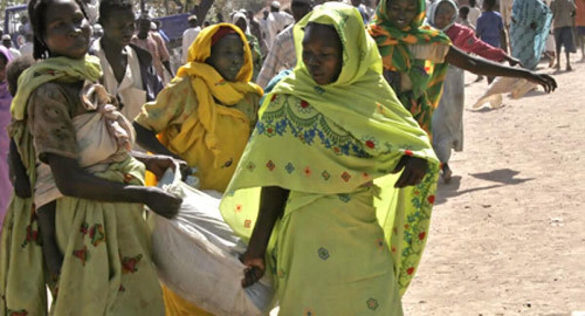 This photo taken February 12, 2008 shows Sudanese women carrying sacks of relief food in Boro Medina, in south Sudan, some of which is instead sold at local markets for meat and other staples.
