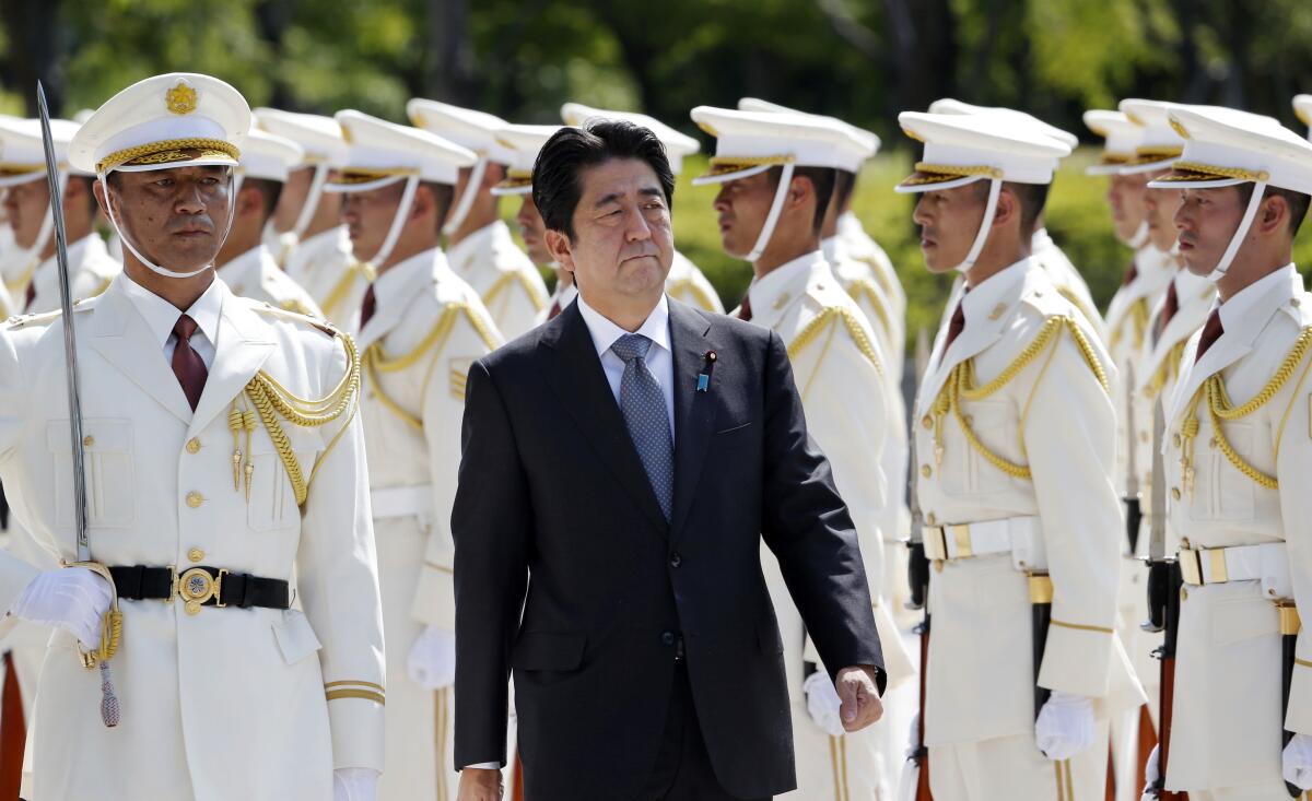 Then-Japanese Prime Minister Shinzo Abe amid an honor guard
